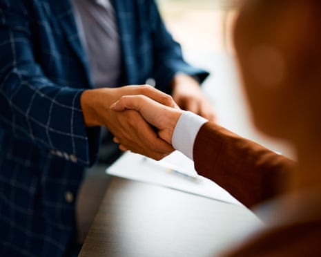 Close up of coworkers handshaking while greeting during business meeting in the office