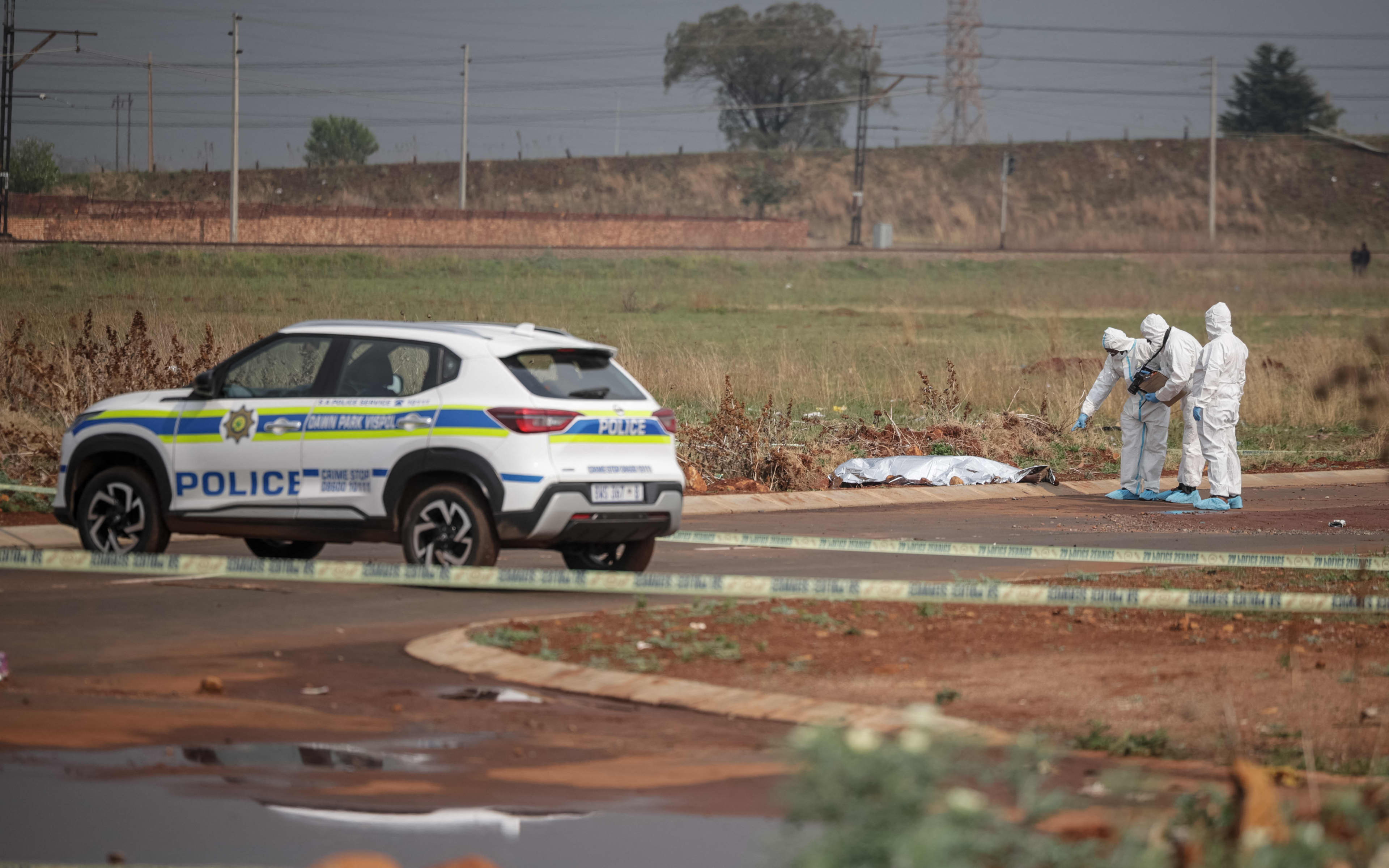EDITORS NOTE: Graphic content / Members of the South African Police Service (SAPS) Forensic Pathology Services work on the crime scene where the body of a woman was discovered in Boksburg on September 17, 2026. South African police are racing to crack the killings of at least nine women whose bodies have been found east of Johannesburg in two months, the latest on August 17. The country has one of the world's highest homicide rates but the discovery of the women's bodies, partially nak