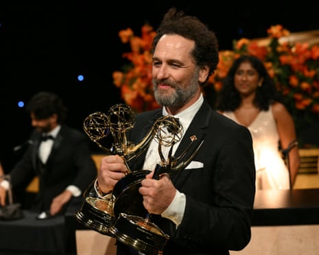 Matthew Rhys smiles while holding three Emmy trophies at the Governors Gala